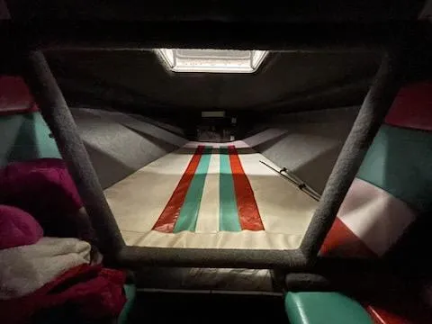 Slide: The Image of Interior cabin of 1995 Cigarette 38 Signature Edition boat with striped bedding. - 16
