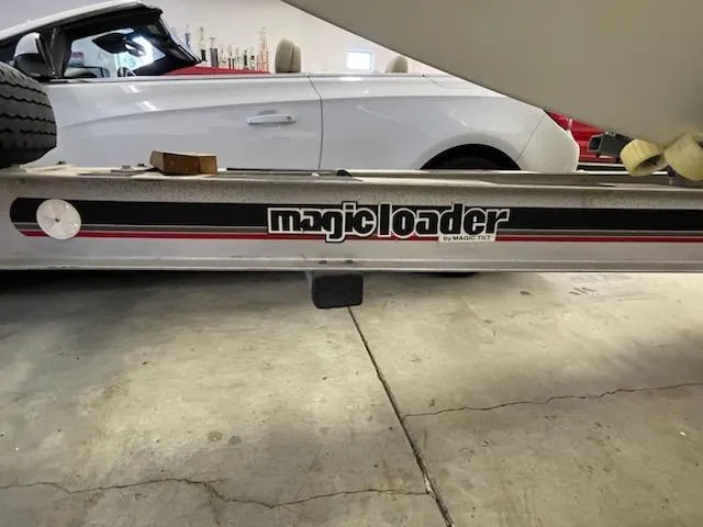 Slide: The Image of Trailer with "Magic Loader" branding beside a white car in a garage. - 17