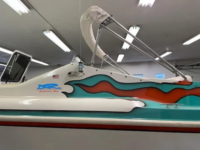 Slide: The Image of 1995 Cigarette 38 Signature Edition boat with vibrant flame design in a well-lit garage. - 2