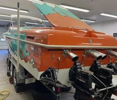 Slide: The Image of 1995 Cigarette 38 Signature Edition boat with vibrant orange and teal design in a garage. - 6
