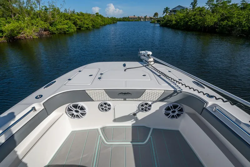 Slide: The Image of Invincible 33 Catamaran 2022 cruising on a serene waterway, surrounded by lush greenery. - 10