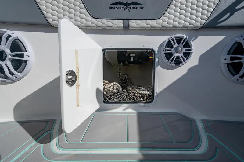Slide: The Image of Open storage compartment on 2022 Invincible 33 Catamaran with speakers and chain inside. - 12