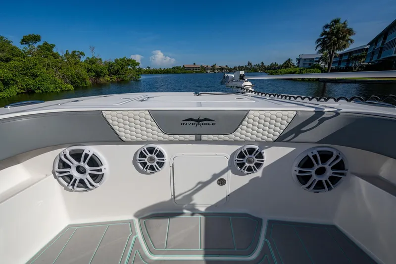 Slide: The Image of 2022 Invincible 33 Catamaran interior with speakers, luxurious seating, and scenic waterway view. - 13