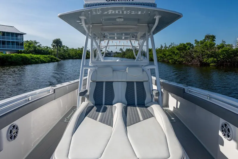 Slide: The Image of 2022 Invincible 33 Catamaran with luxurious seating on a serene waterway. - 16