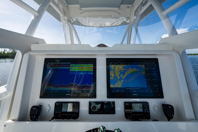 Slide: The Image of 2022 Invincible 33 Catamaran dashboard with dual Garmin displays and navigation equipment. - 2