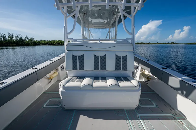 Slide: The Image of 2022 Invincible 33 Catamaran interior with cushioned seating, on calm water under blue sky. - 22