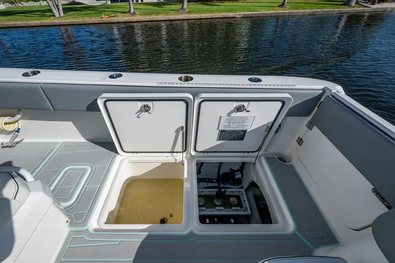 Slide: The Image of 2022 Invincible 33 Catamaran with open storage compartments on deck by the water. - 24