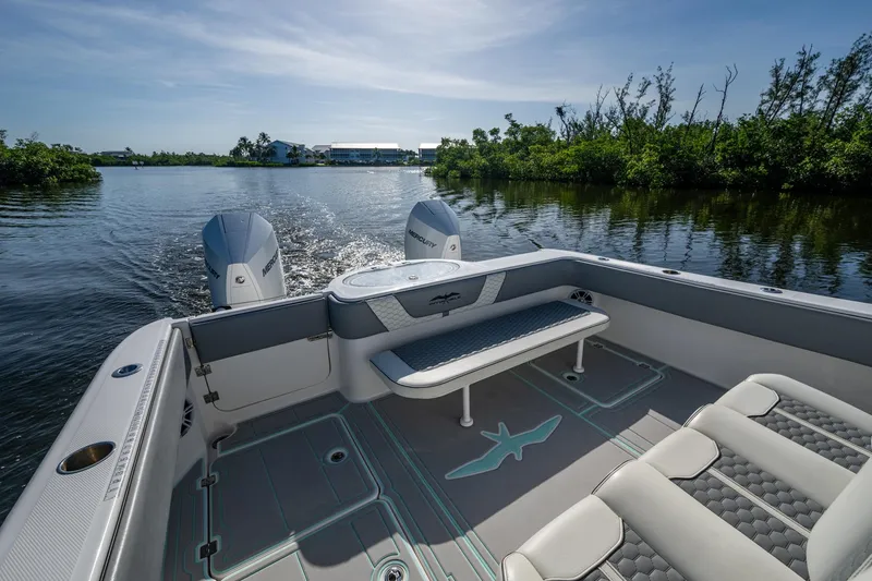 Slide: The Image of Invincible 33 Catamaran 2022 on calm water, featuring spacious seating and dual Mercury engines. - 28