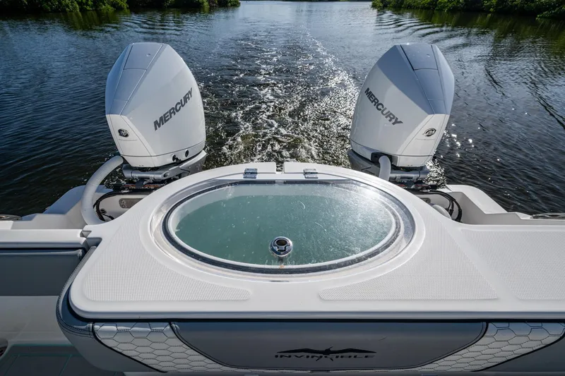 Slide: The Image of 2022 Invincible 33 Catamaran with dual Mercury engines on a serene waterway. - 37