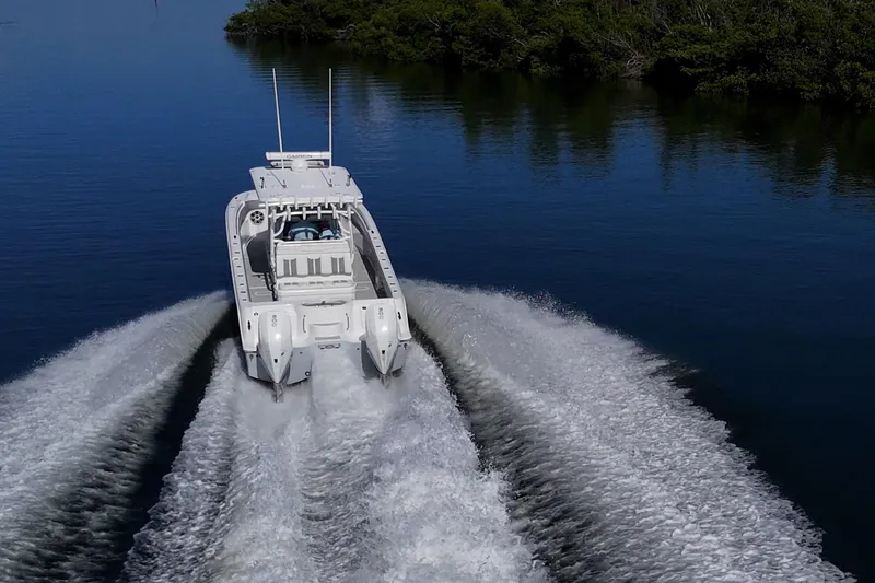 Slide: The Image of 2022 Invincible 33 Catamaran cruising on calm water, leaving a wake trail. - 38