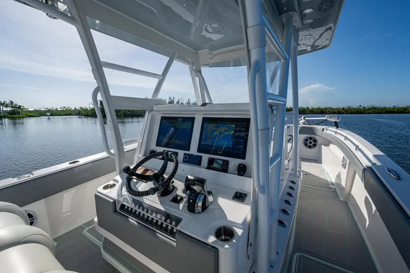 Slide: The Image of 2022 Invincible 33 Catamaran cockpit with advanced navigation system on a serene waterway. - 5
