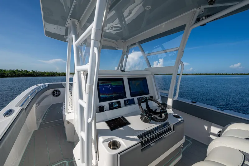 Slide: The Image of 2022 Invincible 33 Catamaran cockpit with advanced navigation system on calm waters. - 6