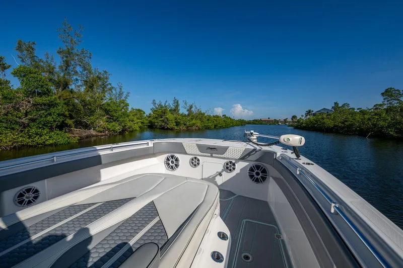 Slide: The Image of 2022 Invincible 33 Catamaran cruising through scenic waterway with lush greenery. - 8