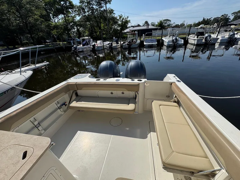 Slide: The Image of 2017 Sailfish 275 DC boat interior with seating, docked in a marina. - 12