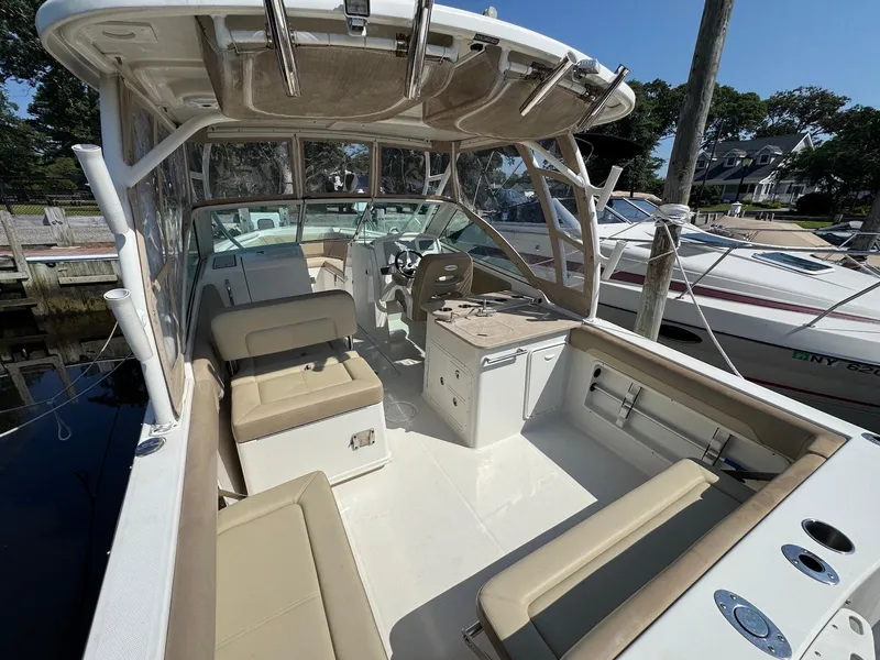 Slide: The Image of 2017 Sailfish 275 DC boat interior with seating and helm, docked at marina. - 14