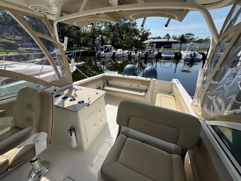 Slide: The Image of 2017 Sailfish 275 DC boat interior with seating and docked view. - 17