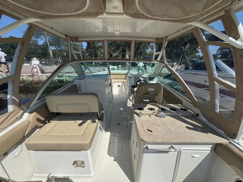 Slide: The Image of 2017 Sailfish 275 DC boat interior with seating and helm, docked outdoors. - 19