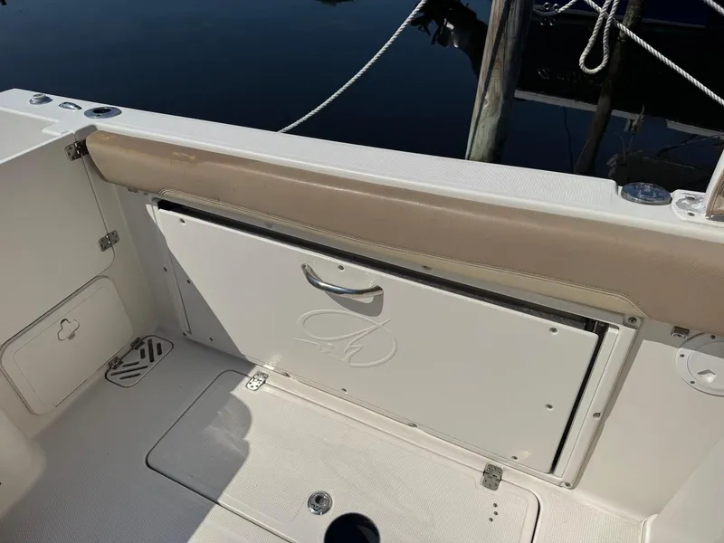 Slide: The Image of 2017 Sailfish 275 DC boat interior with storage compartment and cushioned seating. - 21