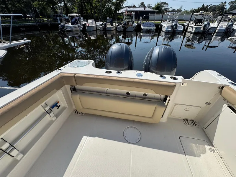 Slide: The Image of 2017 Sailfish 275 DC boat interior with dual engines, docked at marina. - 22