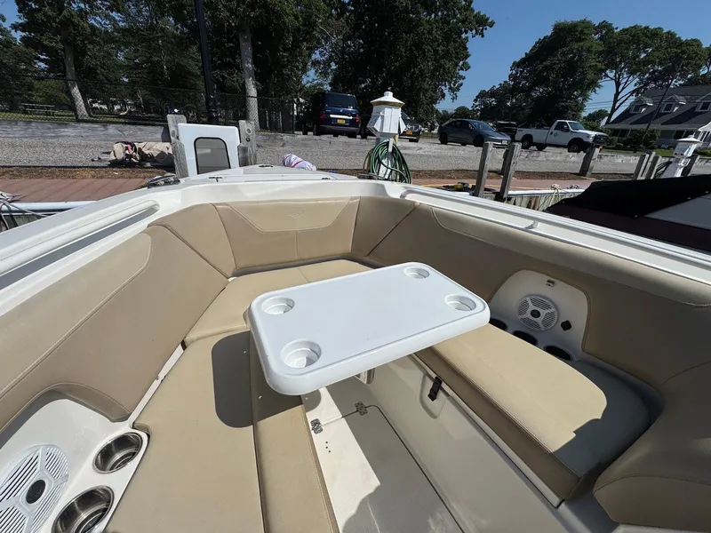 Slide: The Image of 2017 Sailfish 275 DC boat interior with beige seating and a white table. - 24