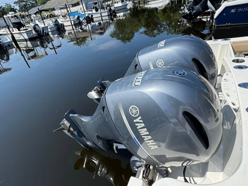 Slide: The Image of Twin Yamaha outboard engines on a 2017 Sailfish 275 DC boat docked at a marina. - 25