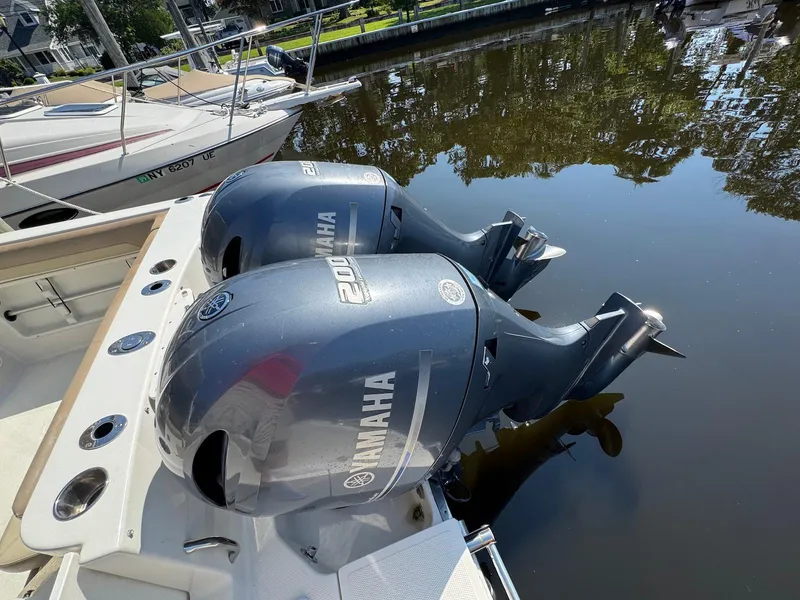 Slide: The Image of Twin Yamaha outboard engines on a 2017 Sailfish 275 DC boat, docked on calm water. - 26
