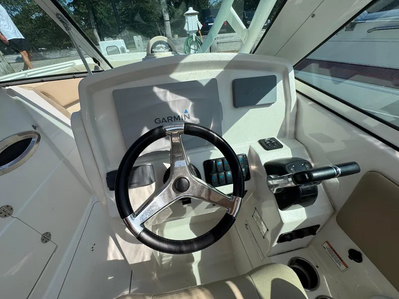 Slide: The Image of 2017 Sailfish 275 DC boat helm with Garmin navigation system and steering wheel. - 4