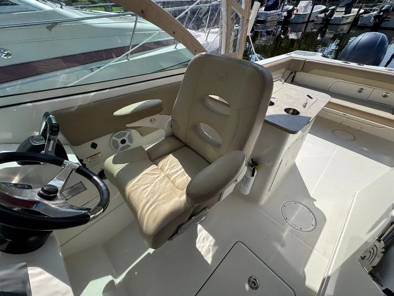 Slide: The Image of 2017 Sailfish 275 DC boat interior with steering wheel and beige seating. - 5