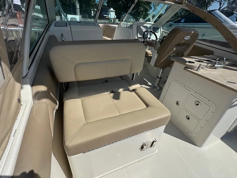 Slide: The Image of Interior of a 2017 Sailfish 275 DC boat with beige seating and steering area. - 7