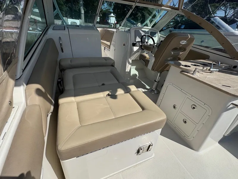 Slide: The Image of 2017 Sailfish 275 DC boat interior with beige seating and steering area. - 8