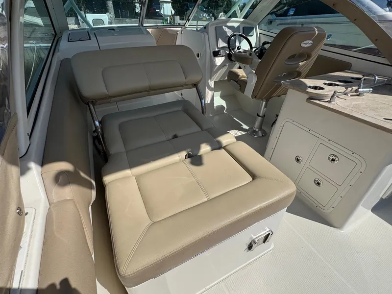 Slide: The Image of 2017 Sailfish 275 DC boat interior with beige seating and steering console. - 9