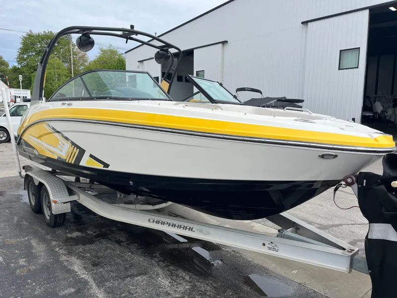 Slide: The Image of 2016 Chaparral Vortex 223 VRX boat on trailer, yellow and white design, parked outside. - 2