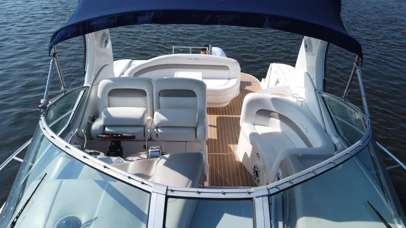 Slide: The Image of 2004 Sea Ray 320 Sundancer boat interior with seating, on calm water. - 14