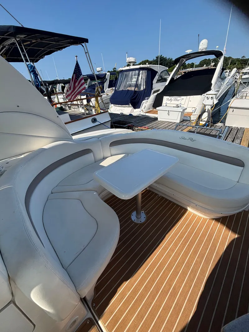 Slide: The Image of 2004 Sea Ray 320 Sundancer yacht with white seating and table on deck. - 17