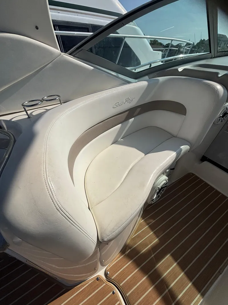 Slide: The Image of 2004 Sea Ray 320 Sundancer interior with white seating and wooden flooring. - 18