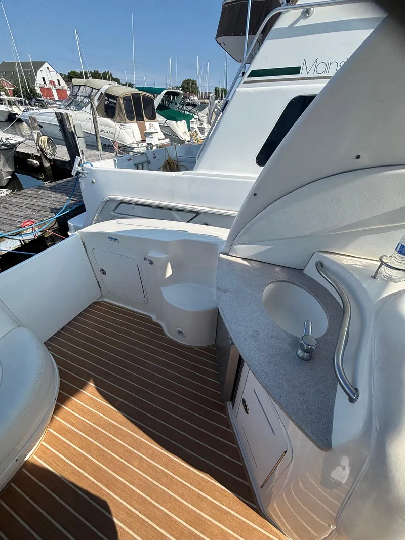 Slide: The Image of 2004 Sea Ray 320 Sundancer boat interior with sink and seating at marina. - 20