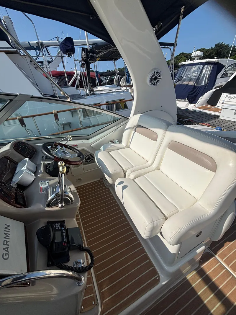 Slide: The Image of 2004 Sea Ray 320 Sundancer cockpit with white seating and control panel. - 21
