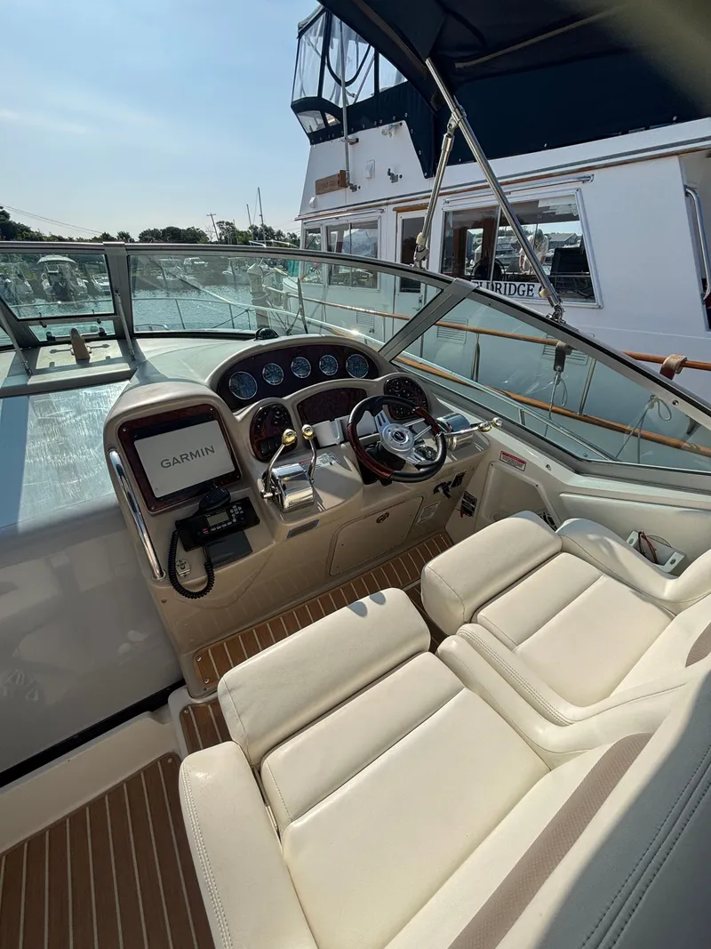 Slide: The Image of 2004 Sea Ray 320 Sundancer helm with Garmin navigation, luxurious seating, and modern controls. - 23