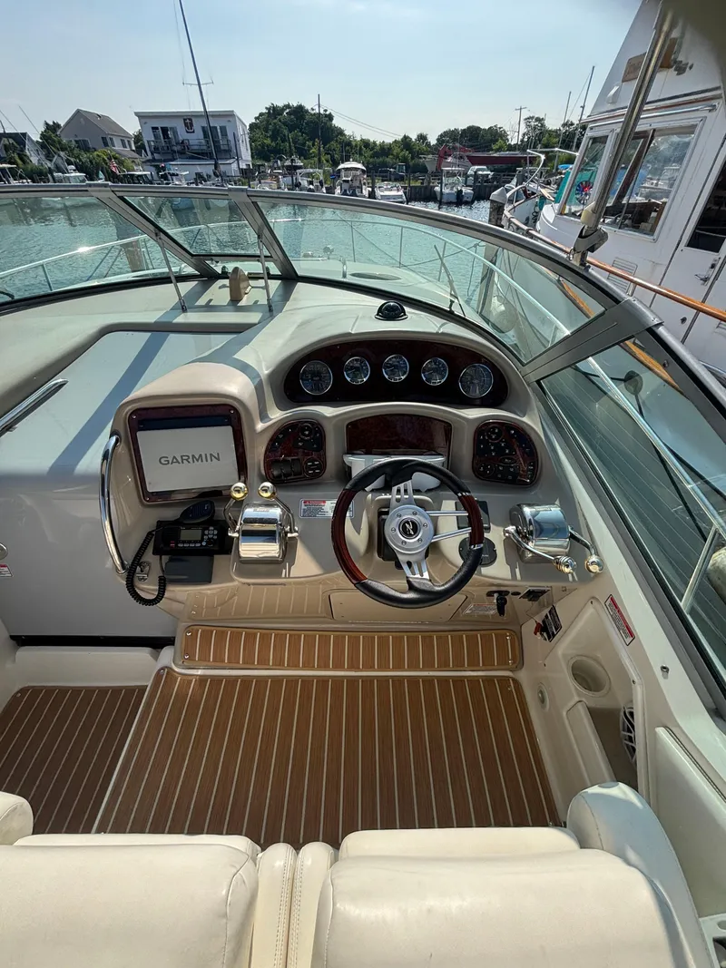 Slide: The Image of 2004 Sea Ray 320 Sundancer helm with Garmin navigation, docked at marina. - 24