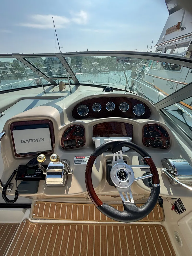 Slide: The Image of Cockpit of 2004 Sea Ray 320 Sundancer with Garmin navigation system and wooden accents. - 25
