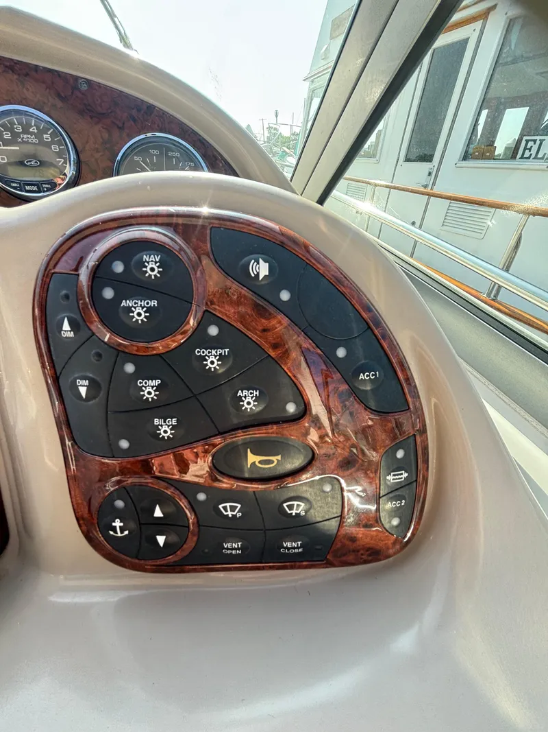 Slide: The Image of Control panel of a 2004 Sea Ray 320 Sundancer boat with various function buttons. - 26