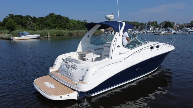 Slide: The Image of 2004 Sea Ray 320 Sundancer yacht on calm water, featuring sleek design and spacious deck. - 3