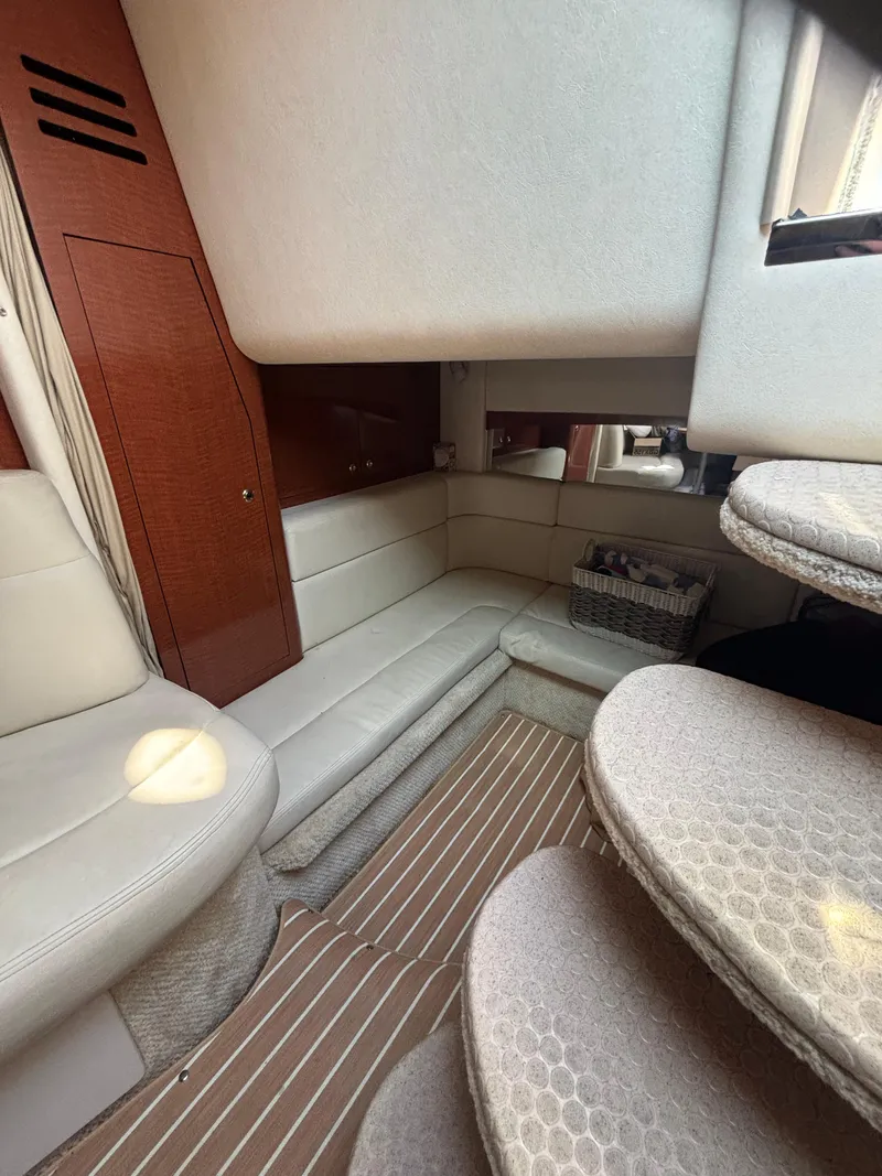 Slide: The Image of Interior of 2004 Sea Ray 320 Sundancer with beige seating and wooden accents. - 37