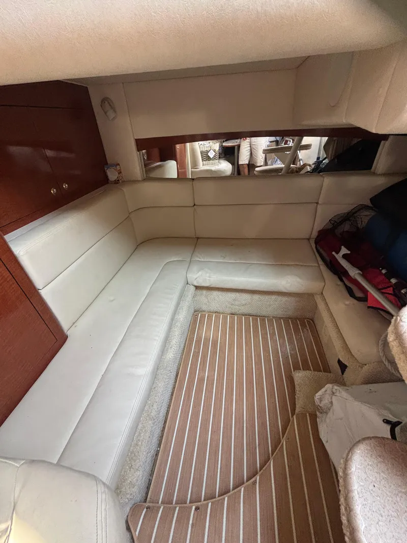 Slide: The Image of Interior of 2004 Sea Ray 320 Sundancer with beige seating and wooden flooring. - 38