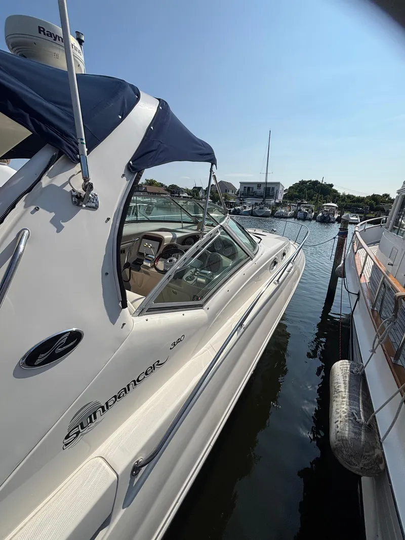 Slide: The Image of 2004 Sea Ray 320 Sundancer docked in a marina under clear blue skies. - 48