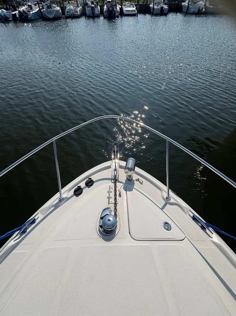 Slide: The Image of Bow view of 2004 Sea Ray 320 Sundancer in a marina. - 49