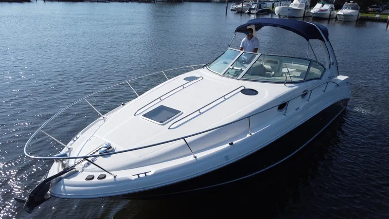 Slide: The Image of 2004 Sea Ray 320 Sundancer boat on calm water, featuring sleek design and spacious deck. - 5