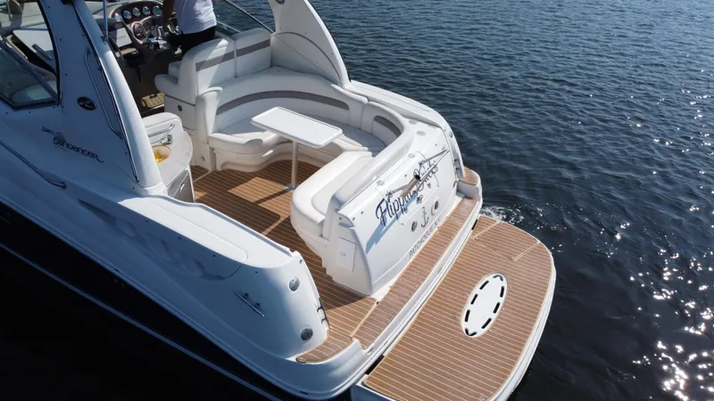 Slide: The Image of 2004 Sea Ray 320 Sundancer yacht with spacious deck and seating on calm water. - 7