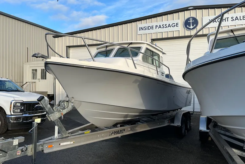 Slide: The Image of 2025 Parker 2420 Sport Cabin boat on trailer at yacht sales facility. - 1