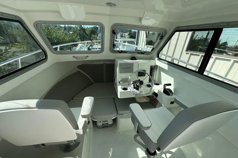 Slide: The Image of 2025 Parker 2420 Sport Cabin interior with steering wheel and seating, featuring Garmin navigation. - 3